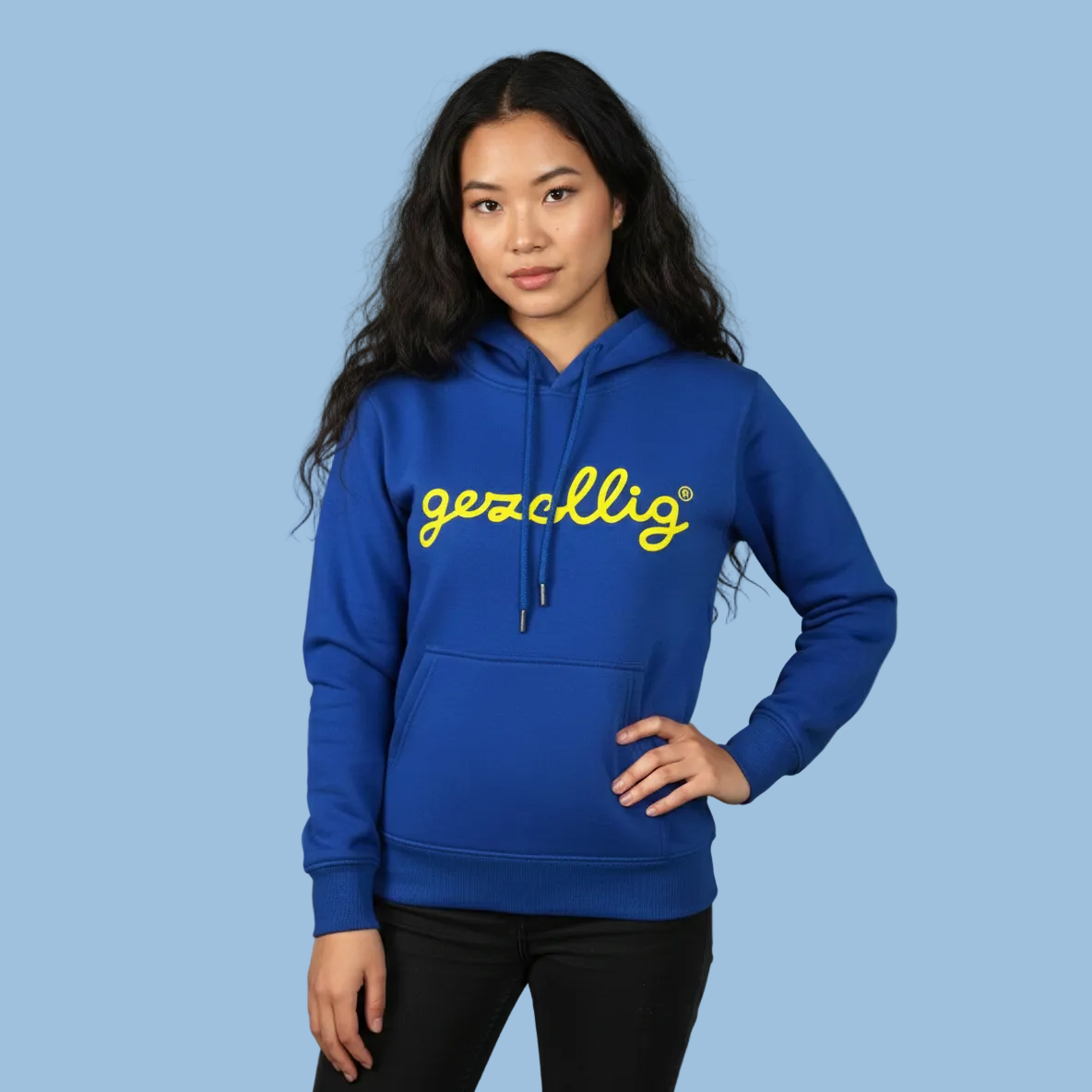 Girl wearing a blue Gezellig hoodie with yellow logo on a light blue background