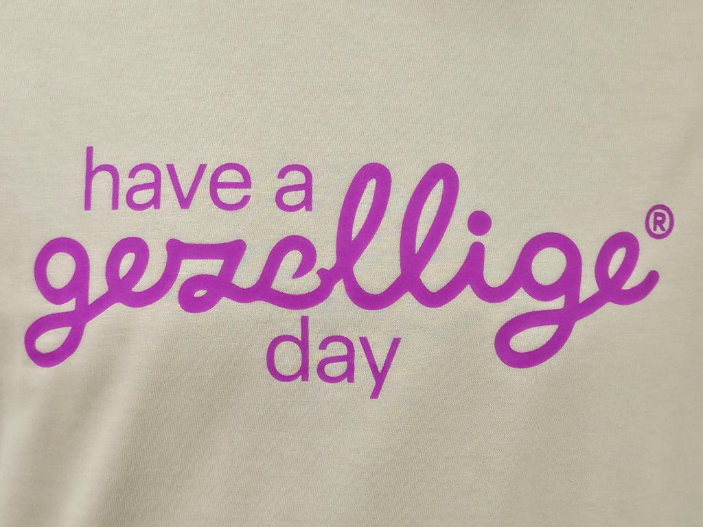 Text 'have a gezellige day' in fuchsia on tan

