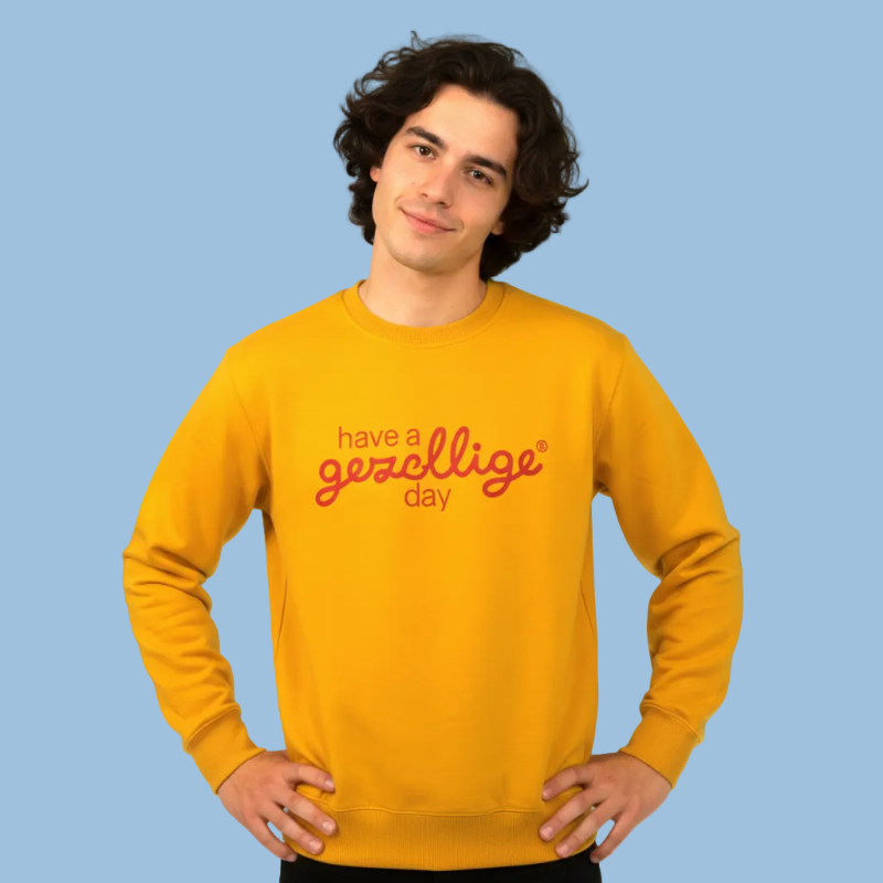 Person wearing a yellow sweatshirt with text on a light blue background